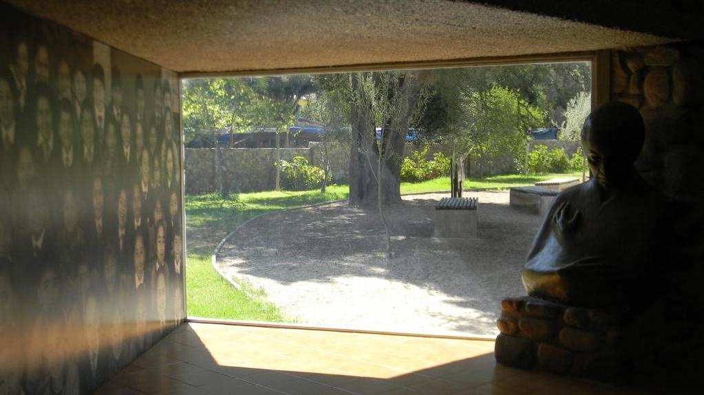 Escultura de Gabriela Mistral junto a una ventana que da al jardín poético del museo