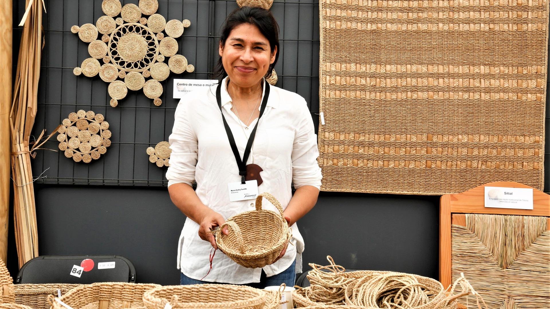 Marta Godoy junto a su artesanía de trenzado en totora