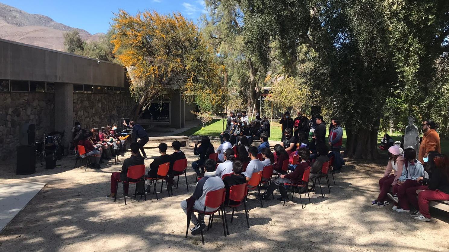 Un ensamble musical escolar presentándose en el Jardín Poético del museo frente a estudiantes de distintos colegios.