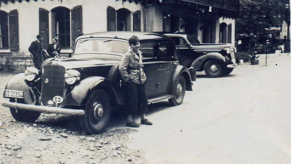 Niño de unos 10 años junto a unos automóviles