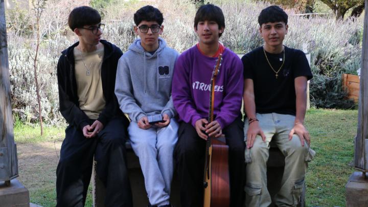 Banda Intruders: 4 jóvenes de 16 años sentados junto a una guitarra acústica en el jardín del museo