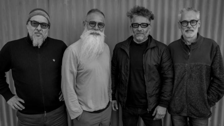 Cuatro hombres de pie mirando de frente. Son los músicos de esta cita.