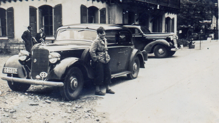 Niño de unos 10 años junto a unos automóviles