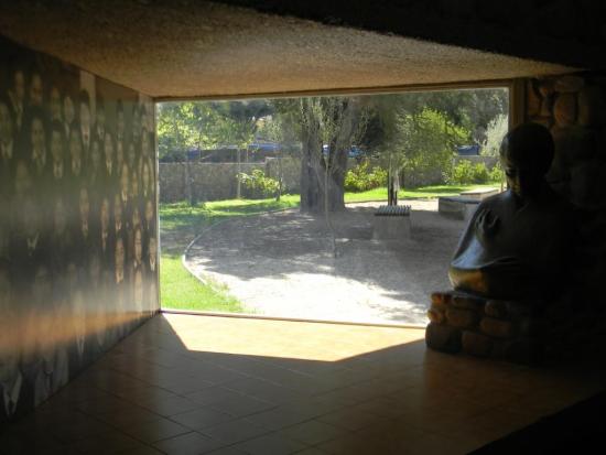 Escultura de Gabriela Mistral junto a una ventana que da al jardín poético del museo