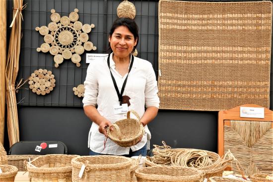 Marta Godoy junto a su artesanía de trenzado en totora