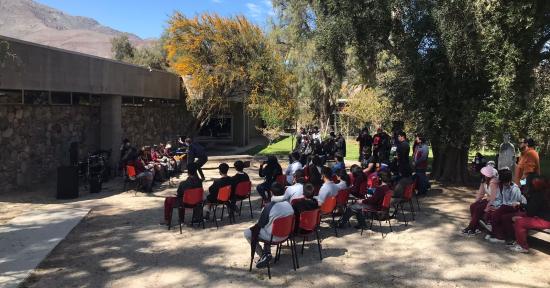 Un ensamble musical escolar presentándose en el Jardín Poético del museo frente a estudiantes de distintos colegios.