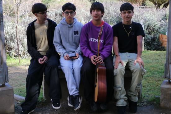 Banda Intruders: 4 jóvenes de 16 años sentados junto a una guitarra acústica en el jardín del museo