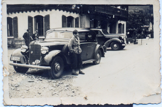 Niño de unos 10 años junto a unos automóviles